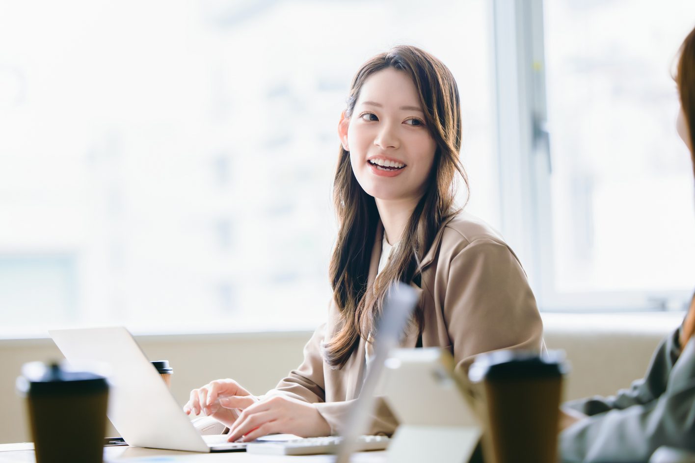お客様と打ち合わせをするアテナ税理士法人の女性スタッフ